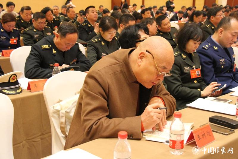 在中国作家协会第九次全国代表大会第三次全体会议上，代表王树增认真作笔记。