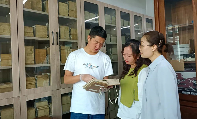 张旻（左）在大通县图书馆了解、翻阅清代印制的经史子集典籍