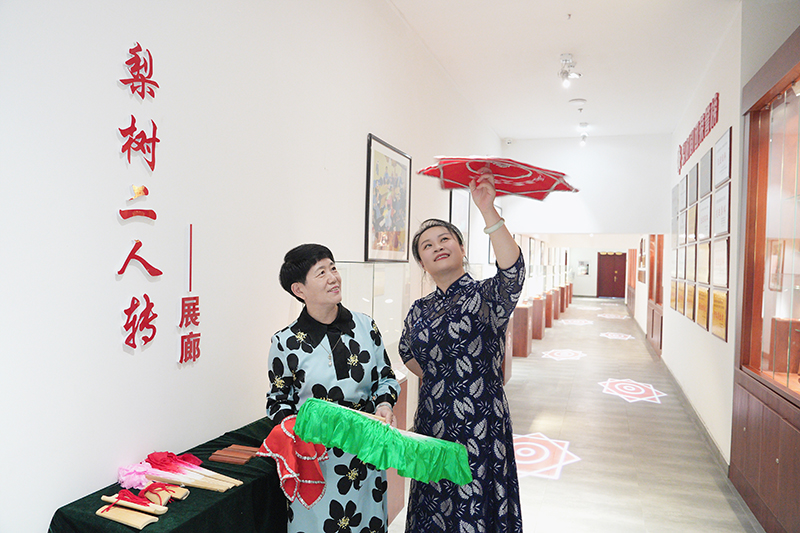 2023年6月29日，在吉林省梨树县地方戏曲剧团梨树二人转展廊，团长赵丹丹（右一）为作家龚保华讲解二人转技巧。