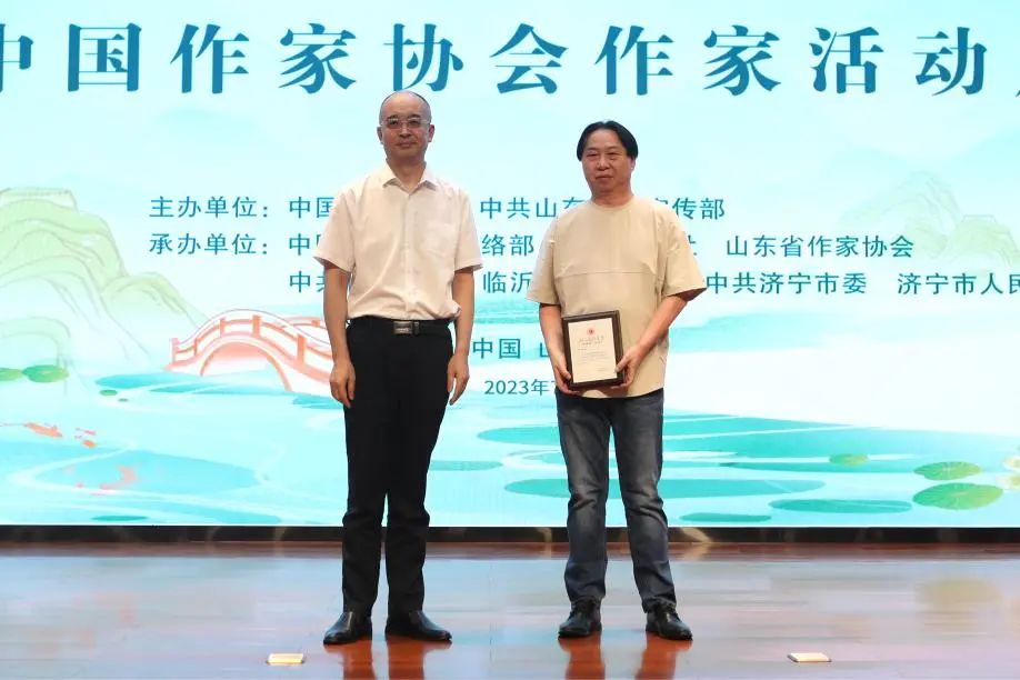 张宏森、吴义勤向参加此次“作家活动周”的中国作协会员逐一颁发专属“入会纪念牌”