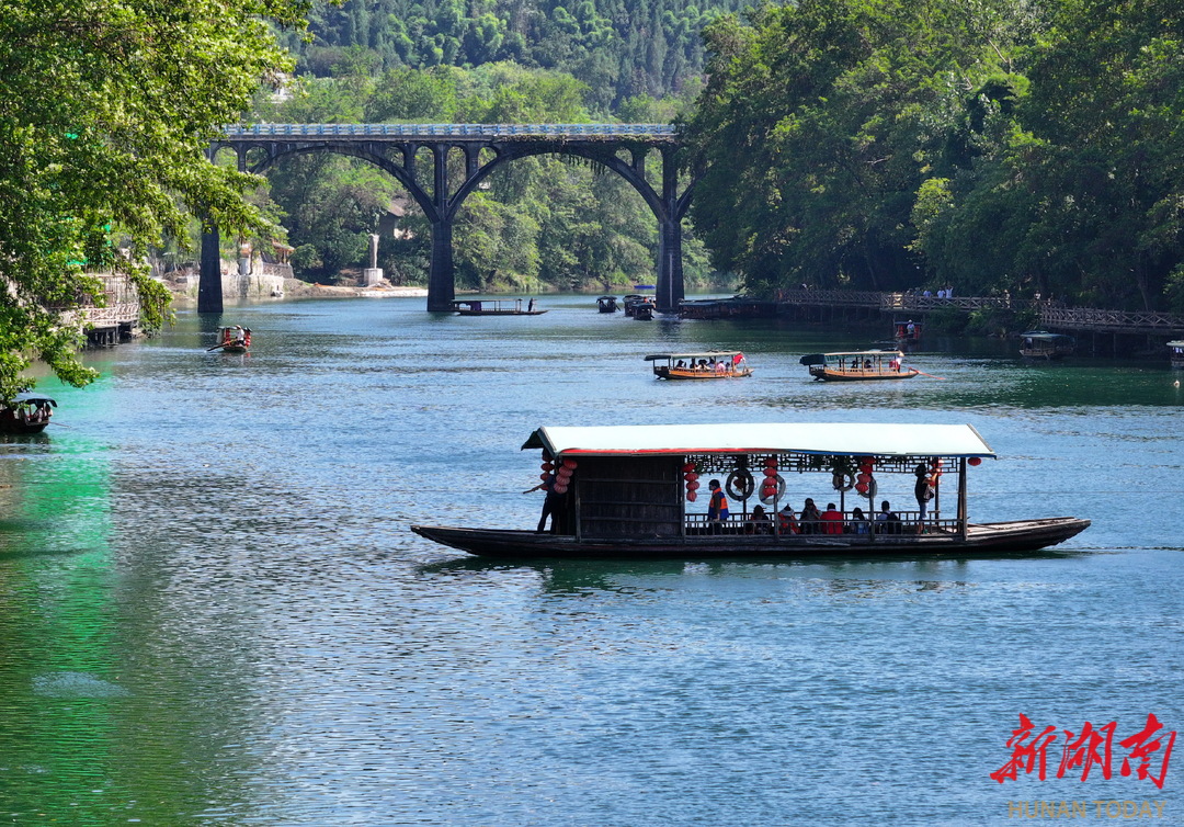花垣县边城镇，游客乘坐拉拉渡过河。