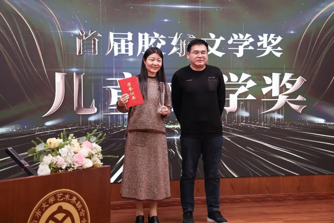 顾建平（右一）  为儿童文学奖获得者刘梅花颁奖