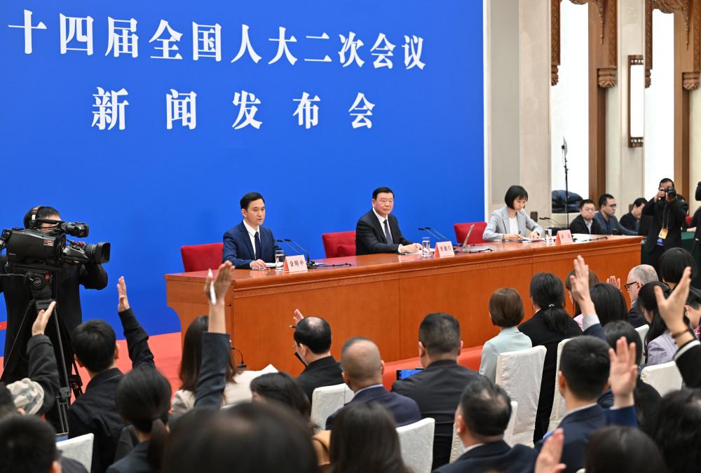3月4日，十四届全国人大二次会议在北京人民大会堂举行新闻发布会。大会发言人娄勤俭就大会议程和人大工作相关问题回答中外记者的提问。这是记者举手提问。 新华社记者 才扬 摄