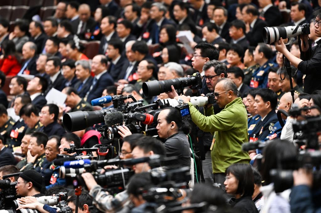 3月8日，十四届全国人大二次会议在北京人民大会堂举行第二次全体会议。这是记者在会议现场采访。新华社记者 牟宇 摄