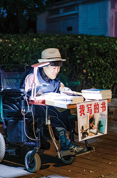 ▲2023年9月，洛洛在北京后海摆摊卖书。（受访者供图）