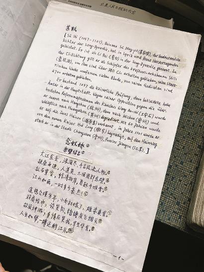 书桌前的谭余志和他的手稿（右）。