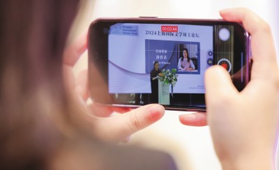 在2024上海国际文学周主论坛的会场，一位观众在用手机录制日本推理小说家凑佳苗的发言。上海国际文学周供图