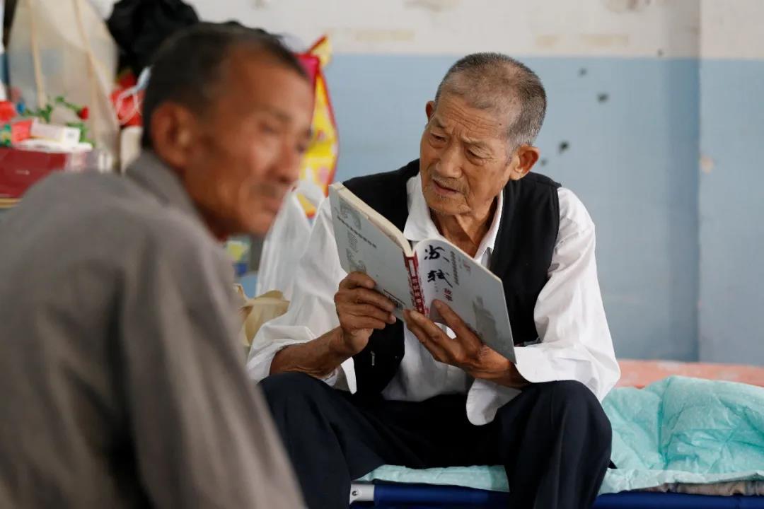 81岁老人洪灾中坚持读书