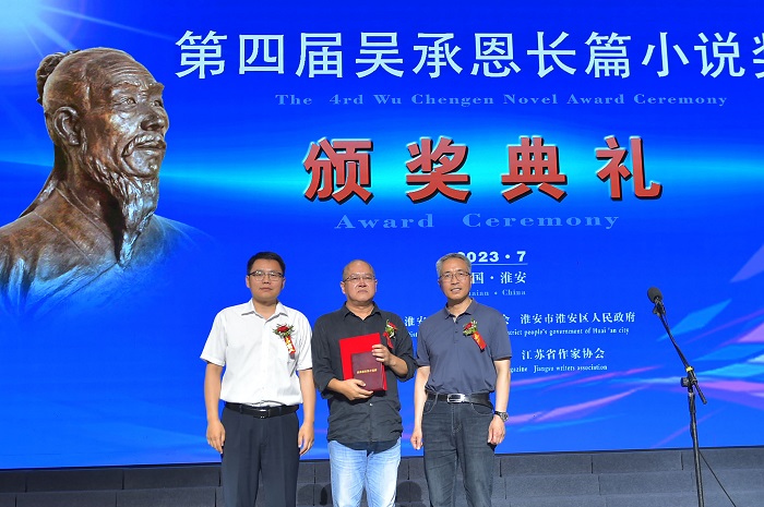 《人民文学》杂志社副主编陈涛，淮安市文联党组书记、主席王维国为庞贝颁奖