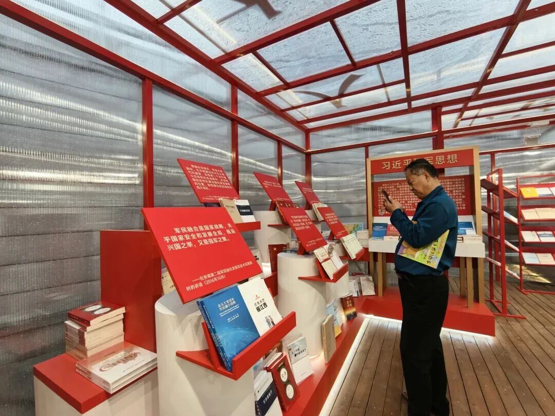 在军事主题书架前驻足的大爷