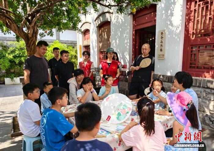 7月5日,山东省济南市老舍旧居举办暑期研学活动,学生们在石榴树下彩绘油纸伞。 邢爱芹 摄